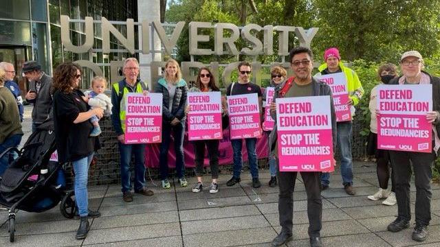 University of Brighton staff holding placards that say: "Defend education. Stop the redundancies."