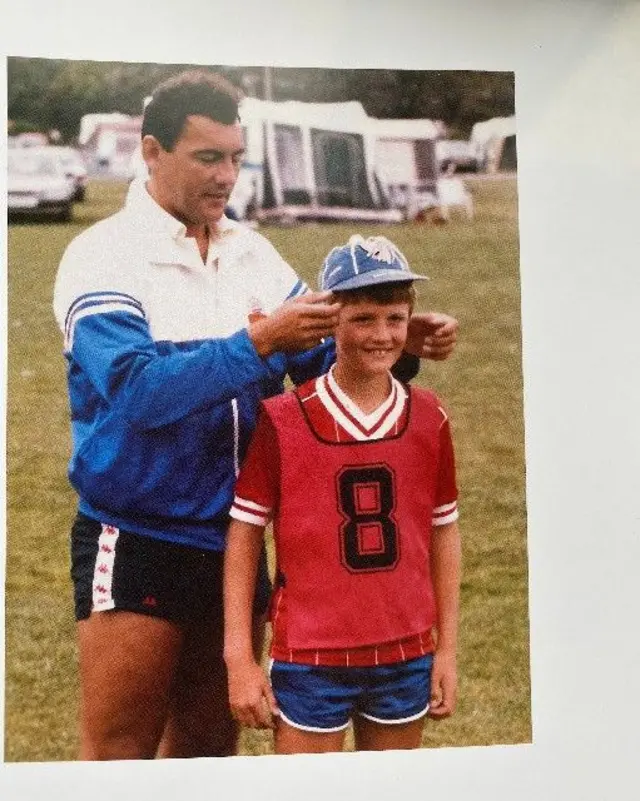 Ray Kennedy puts an England cap on a child