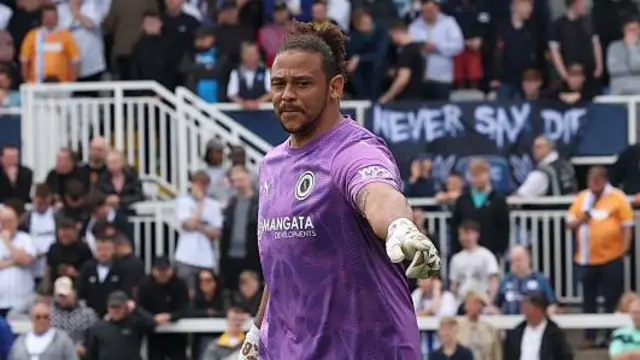 Nathan Ashmore in action for Boreham Wood wearing a purple short-sleeved goalkeeping shirt