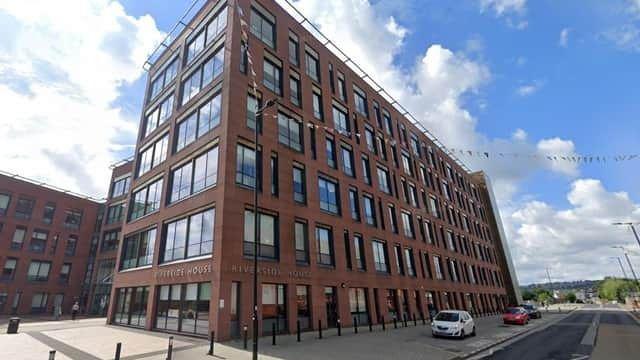 A six-storey office block with red bricks and large glass windows.