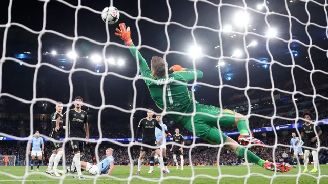 Shot from behind of goalkeeper trying to save Erling Haaland goal