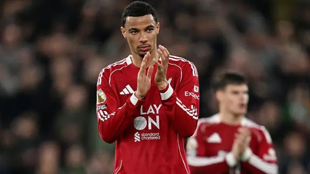 Hugo Ekitike, wearing Liverpool's red home kit, applauds the fans while looking disappointed