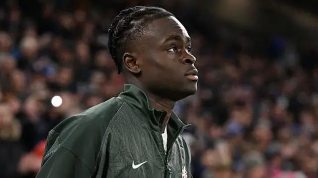 Tyrique George walking out onto the pitch away at Cardiff City in his training kit