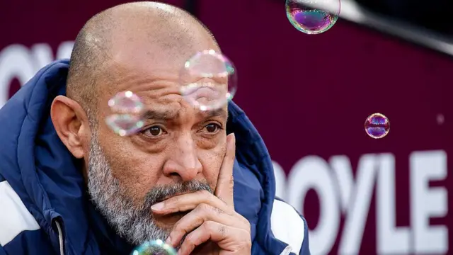 Nuno Espirito Santo holding his face and bubbles floating around him
