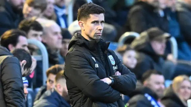 Eric Ramsay with arms folded on the Albion sideline at Portsmouth