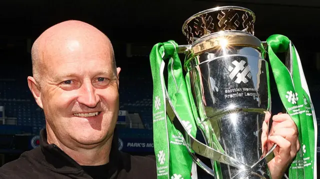 Hibernian Head Coach Grant Scott lifts the Scottish Women's Premier League trophy during a Scottish Women's Premier League match between Rangers and Hibernian at Ibrox Stadium