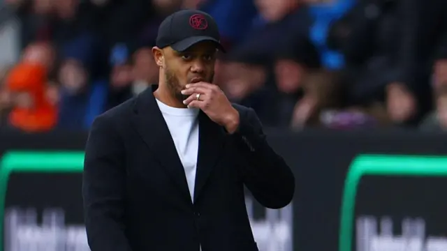 Vincent Kompany stands on the touchline