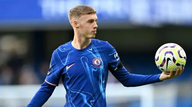 Cole Palmer of Chelsea holds the match ball following the Premier League match between Chelsea FC and Brighton & Hove Albion FC at Stamford Bridge