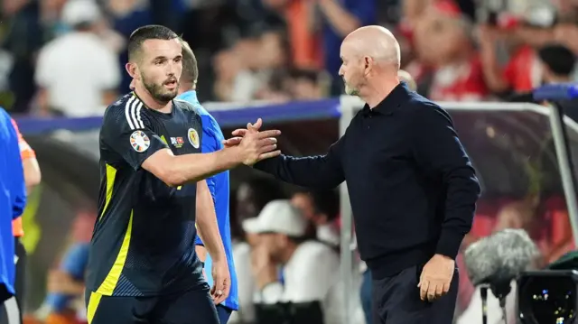 Scotland's John McGinn leaves the pitch as a substitute and shakes hands with manager Steve Clarke (right) during the UEFA Euro 2024 Group A match at the Cologne Stadium in Cologne