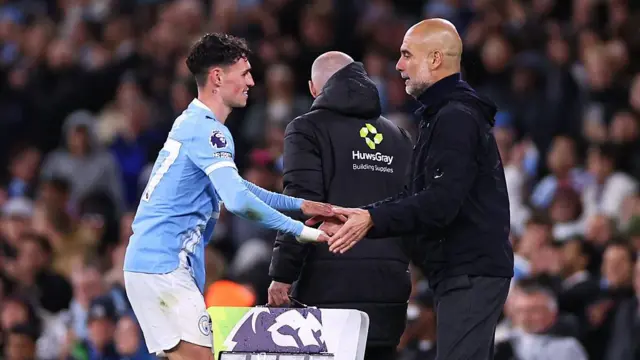 Pep Guardiola embraces Phil Foden as he is substituted
