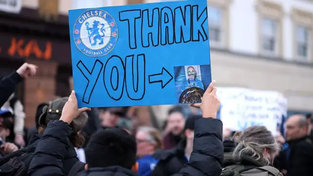 A Chelsea fan holds up a sign reading "Thank you" aimed towards former manager, Enzo Maresca