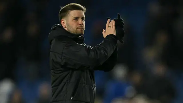 Brighton's German head coach Fabian Hurzeler applauds fans on the pitch.