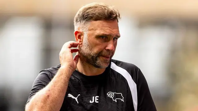 John Eustace scratches his head and looks perplexed on the Derby touchline