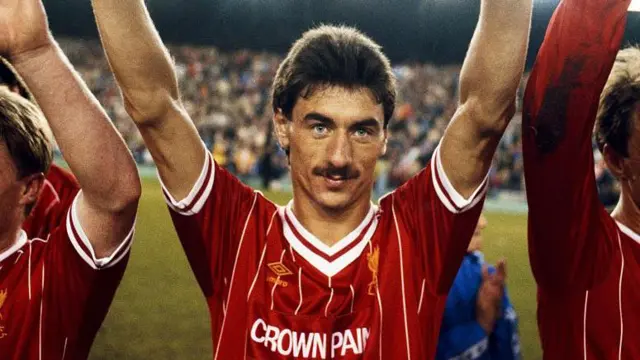 Ian Rush looks on and raises his arms wearing a red Liverpool kit
