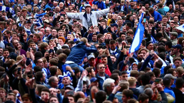 Brighton fans celebrate on the pitch