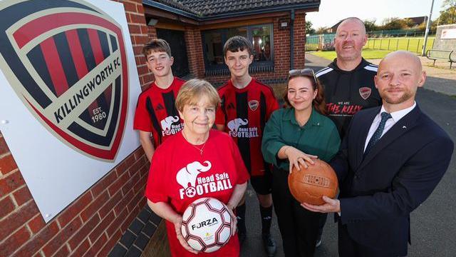 Representatives of Killingworth FC and Head Safe campaign holding balls and wearing football tops with the campaign's logo.