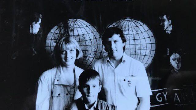 Black and white photo of a young Dafydd with his mum Mair and dad Hywel Francis, standing in front of the Onllwyn miners banner, in the Donbas in the Soviet Union.