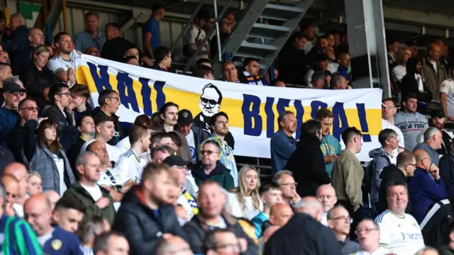 Fans of Leeds United hold up a banner of former manager Marcelo Bielsa