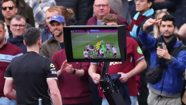 Referee Chris Kavanagh reviews VAR before disallowing a late goal from Callum Wilson
