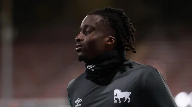 Somto Boniface warms up in black training kit before a match