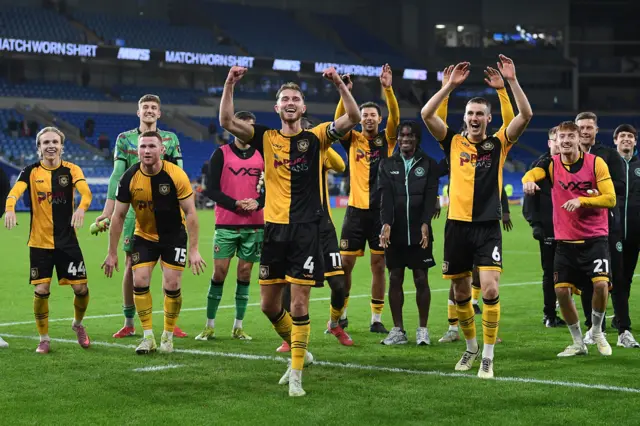 Newport players celebrate with their fans at full time