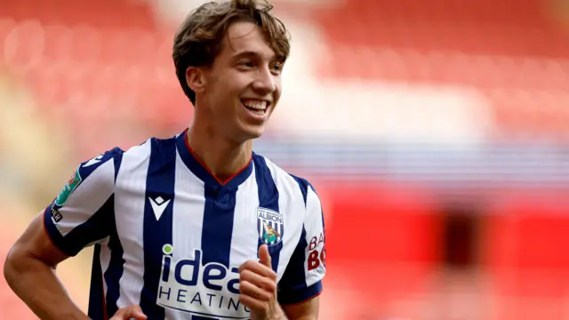 A close-up of Harry Whitwell smiling in his West Bromwich Albion home kit during their game against Rotherham on Saturday.