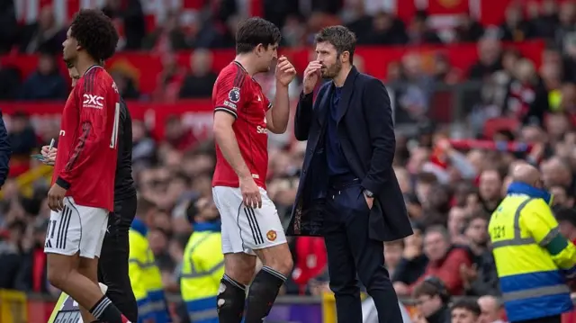 Manchester United defender Harry Maguire (centre) speaks to head coach Michael Carrick after coming off towards the end of the 2-1 win over Crystal Palace