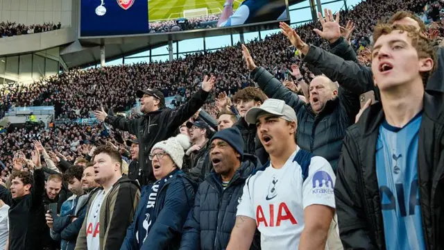 Tottenham fans at Tottenham Hotspur Stadium. They sing inside the arena.