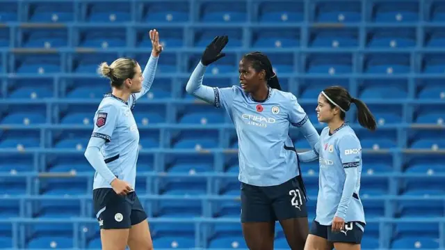 Bunny Shaw high fives Alanna Kennedy and Yui Hasegawa after opening the scoring