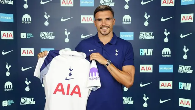 Joao Palhinha holding up Tottenham shirt at his signing for the club