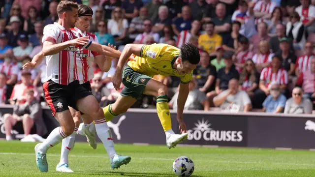 Wrexham striker Kieffer Moore goes tumbling after being pushed in the back by Southampton's Ronnie Edwards