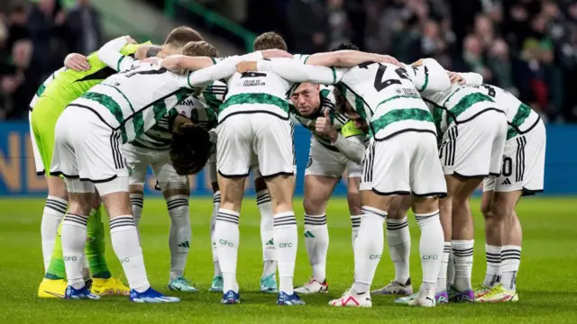 Celtic fans huddle together. 