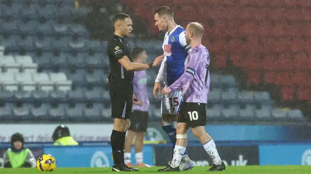 Referee Ruebyn Ricardo talks to Blackburn captain Sean McLoughlin and Sheffield Wednesday skipper Barry Bannan