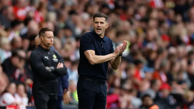 John Mousinho clapping on the sidelines