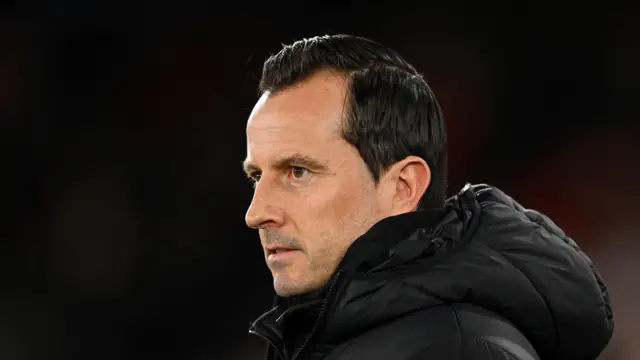 Julien Stephan watching QPR play wearing a thick black padded jacket