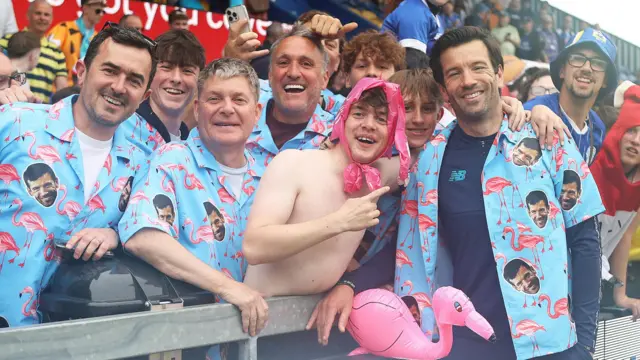 Cardiff City head coach Brian Barry-Murphy (right) poses with fans wearing blue shirts decorated with his face and pink flamingos