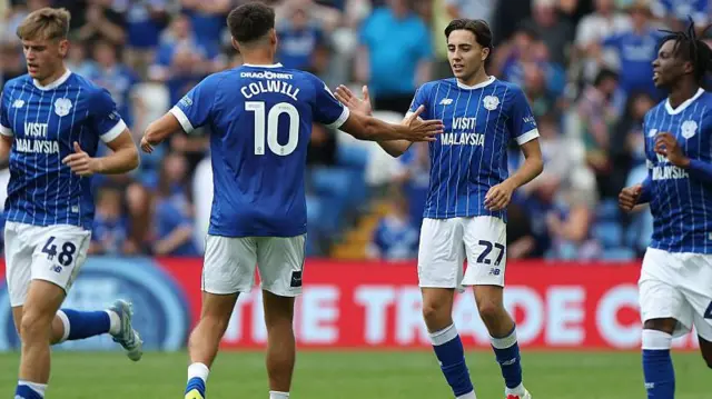 Rubin Colwill with his back to the camera celebrates with Joel Colwill in a game for Cardiff City