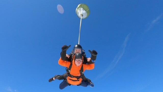 Teen and skydrive instructor mid skydive 