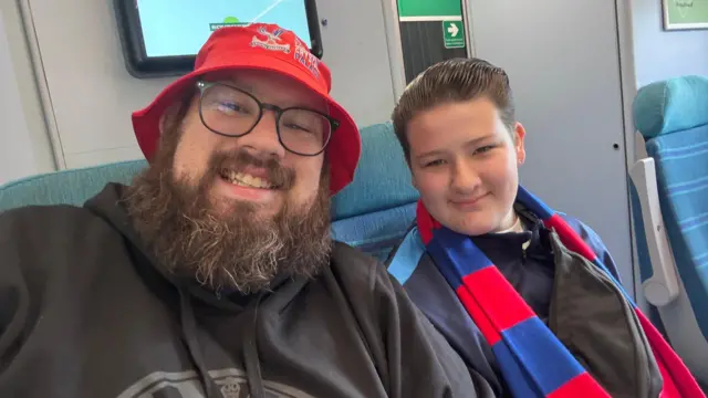 Father and daughter pose for a picture on the train