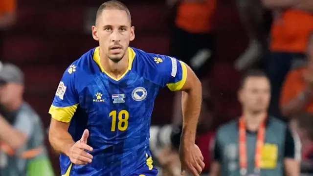 Nikola Katic in action for Bosnia, wearing a blue shirt with yellow trim