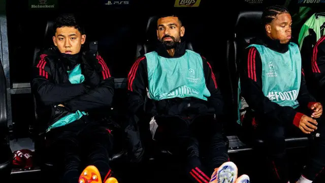 Wataru Endo and Mohamed Salah of Liverpool look on from the bench
