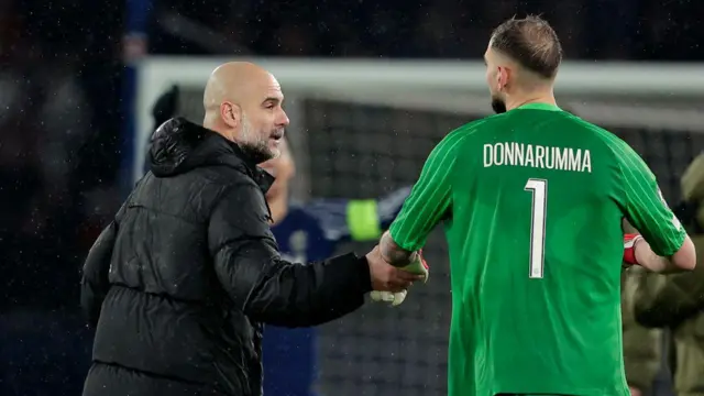 Pep Guardiola interacts with Gianluigi Donnarumma on the pitch after Manchester City lose to PSG in the Champions League in January 2025