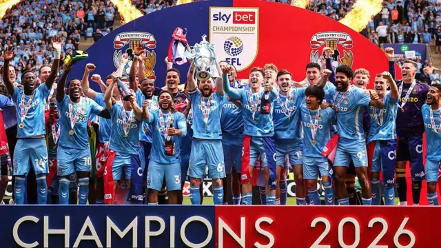 Coventry City players lift EFL Championship trophy on the pitch