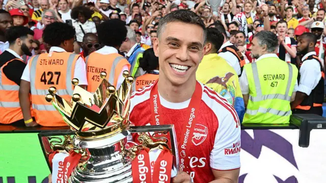 Leandro Trossard poses with the Premier League trophy after Arsenal are crowned champions