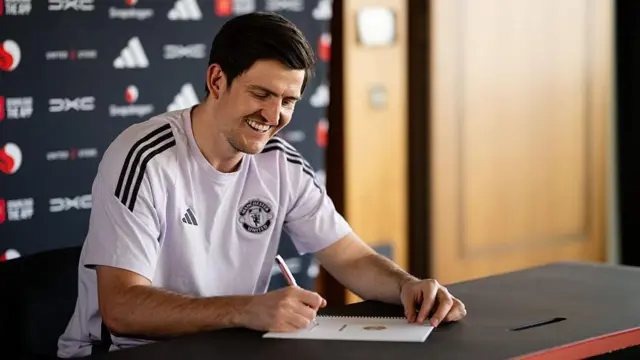 Harry Maguire of Manchester United poses after signing a contract extension