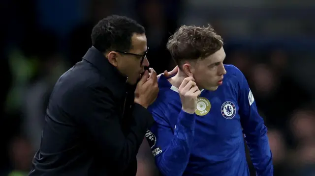 Liam Rosenior (left) talks into the ear of Cole Palmer