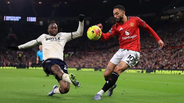 Aaron Wan-Bissaka and Matheus Cunha compete for the ball
