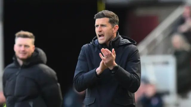 Portsmouth manager John Mousinho applauds his players from the touchline at Middlesbrough.