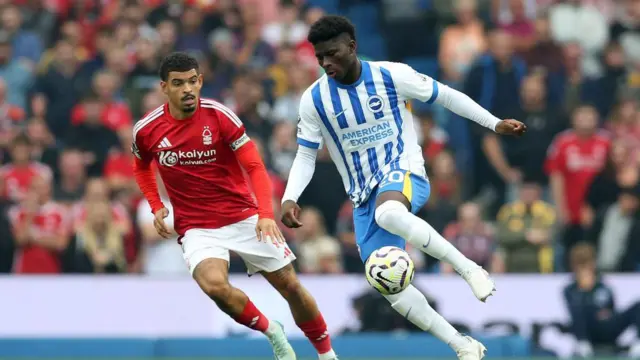 Carlos Baleba of Brighton & Hove Albion controls the ball under pressure from Morgan Gibbs-White of Nottingham Forest during the Premier League match between Brighton & Hove Albion FC and Nottingham Forest FC at Amex Stadium