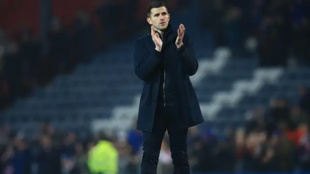 Portsmouth boss John Mousinho applauds fans at Ewood Park